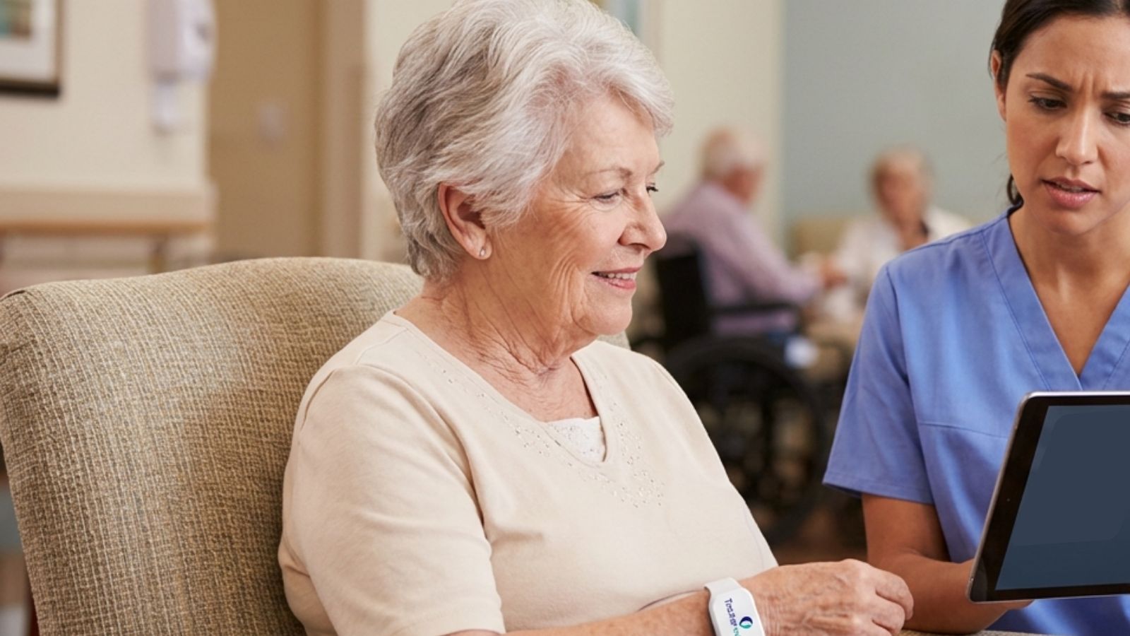 Senior patient wearing a Trackerwave BLE wristband with an automated alert visualised on a nurse’s mobile device